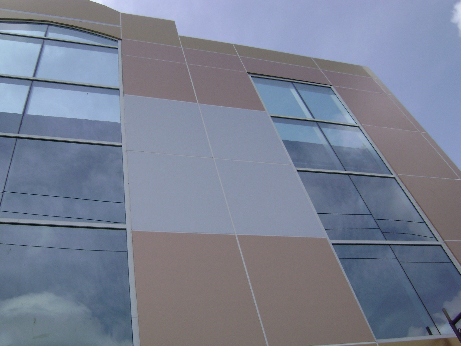 Bronze and grey aluminium composite panel facade with structural glazing